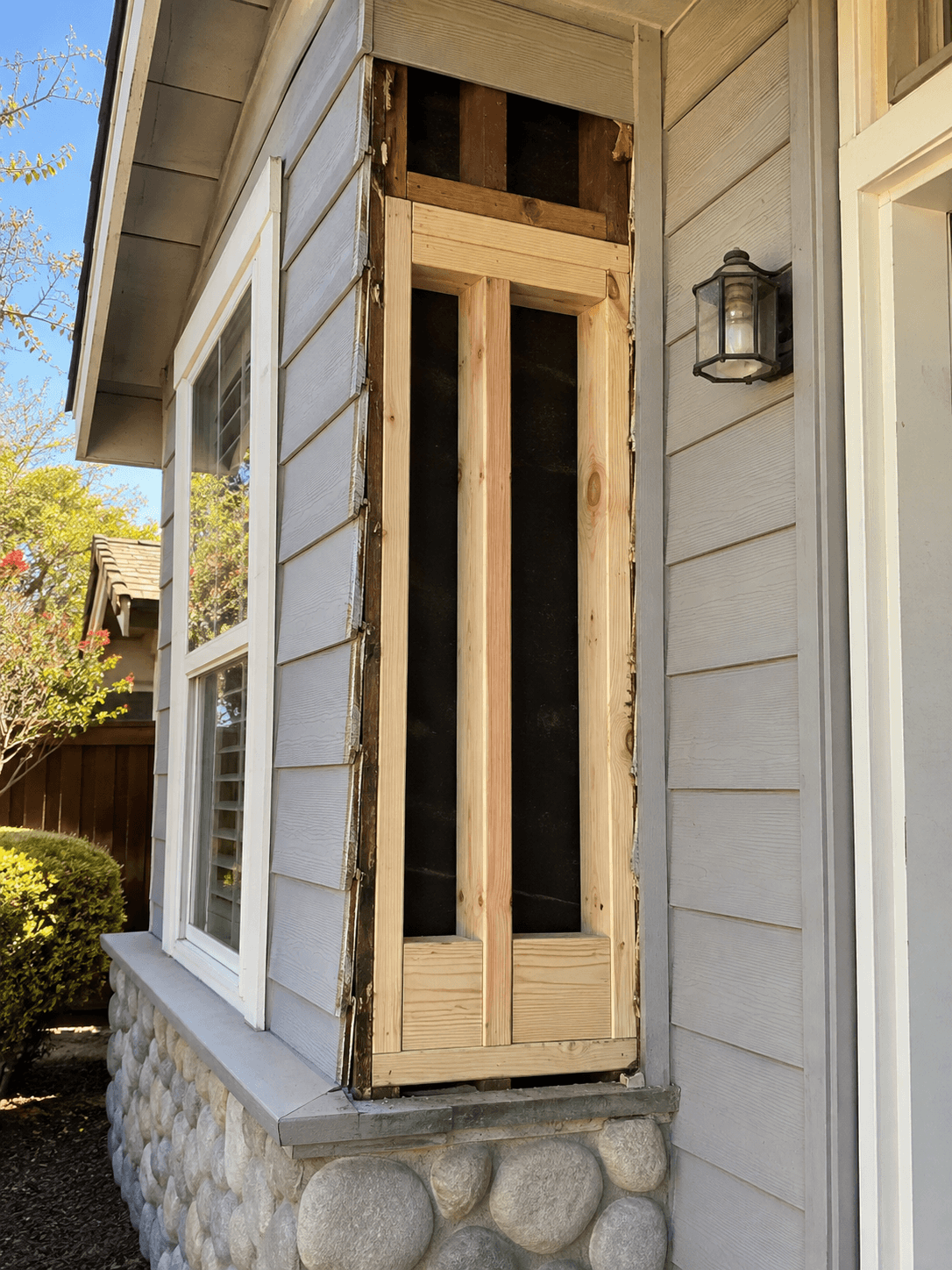 Termite damage repair in Sacramento, CA with exposed exterior wall framing and replacement lumber installed on a residential home.